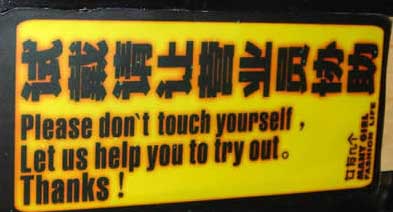 A sign with Chines characters reads «Don't touch yourself. Let us help to try out» in English